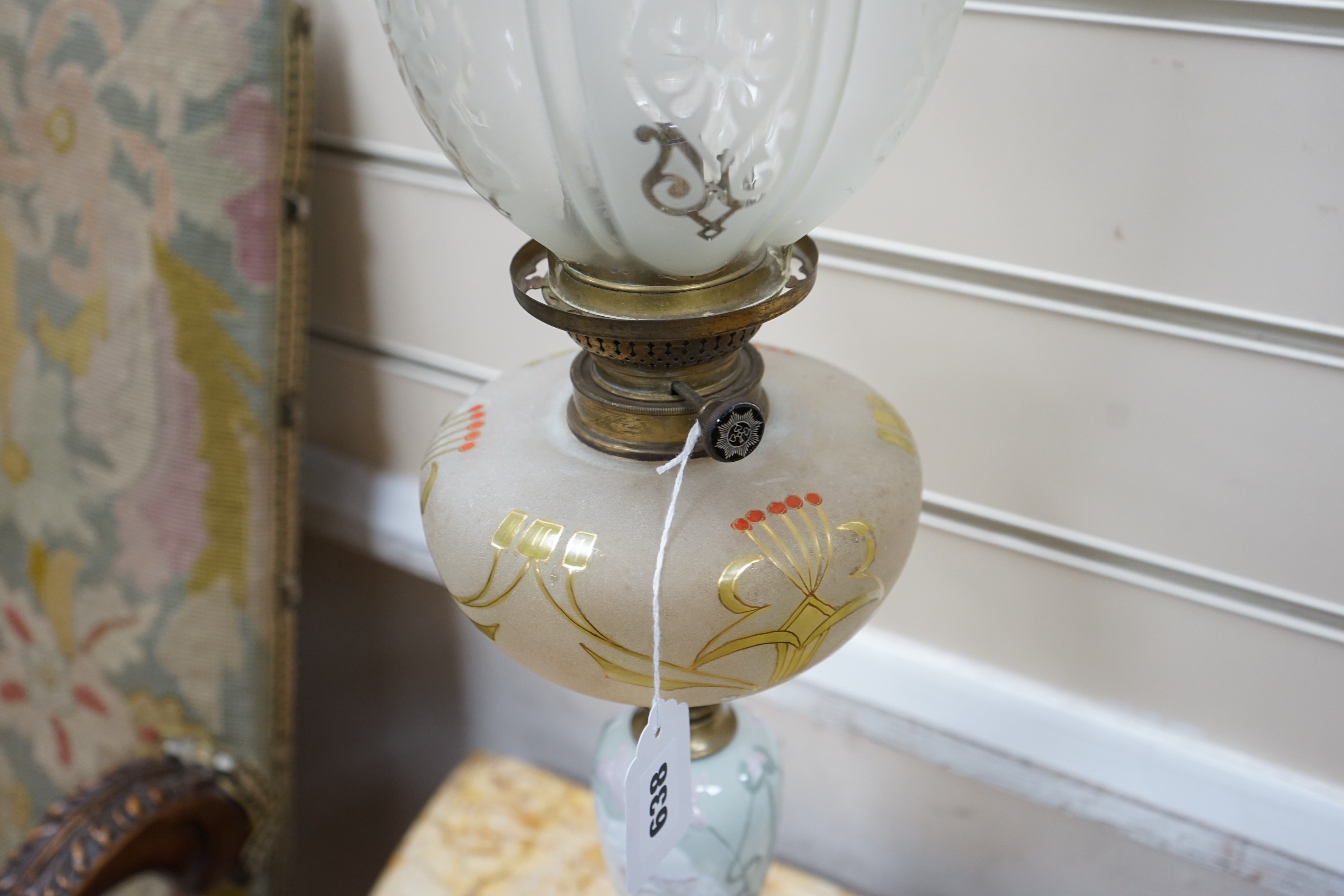 A pair of Art Nouveau decorative porcelain, brass and glass oil lamps. 64cm tall
